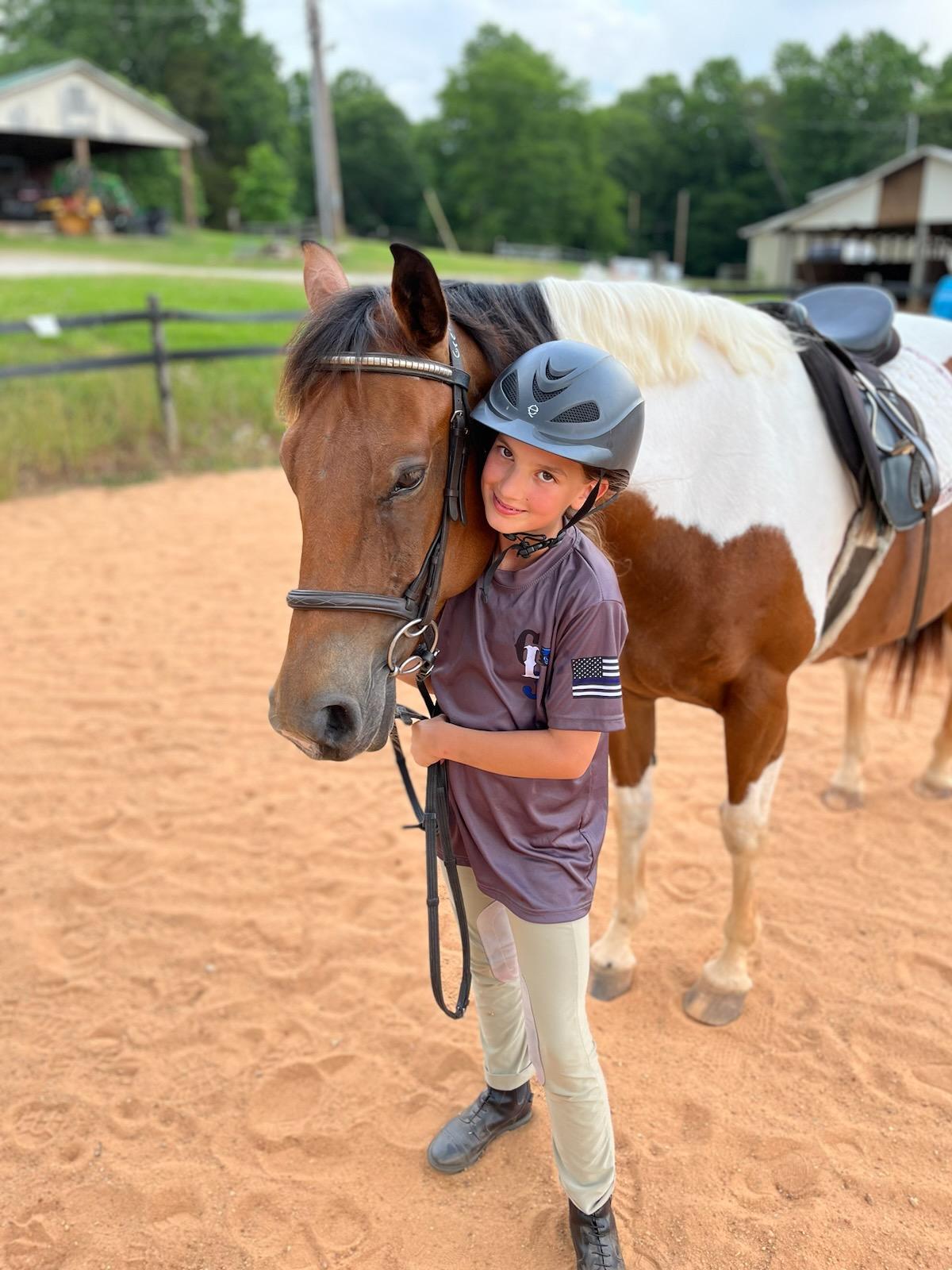 Child happily posing with horse